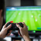 An image of a man playing football video games on a playstation