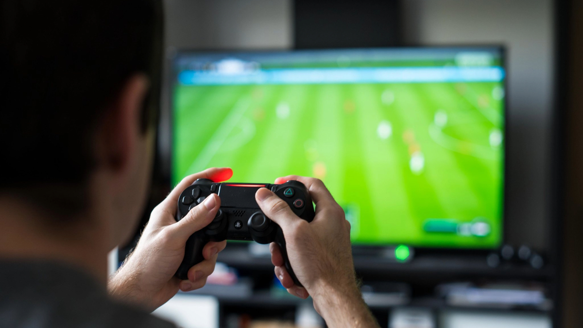 An image of a man playing football video games on a playstation